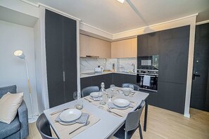 A modern kitchen with dark cabinetry, a microwave, and an oven. - Functional and Bright Apartment in Providencia (Santiago)