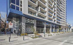 Un edificio moderno con varios balcones y un letrero que indica que no se permiten taxis sin pasajeros.