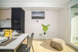 Una cocina moderna con gabinetes oscuros, horno empotrado y microondas.