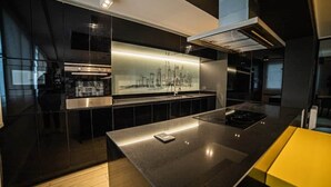 Cocina moderna con gabinetes negros, extractor de acero inoxidable y salpicadero con vista a la ciudad.