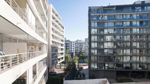 A multi-story residential building with balconies, a swimming pool, and a gated courtyard. - Modern Chic Oasis: Sophisticated Las Condes Stay (Las Condes)