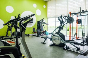 A gym with various exercise equipment, including a treadmill, weight machines, and free weights.