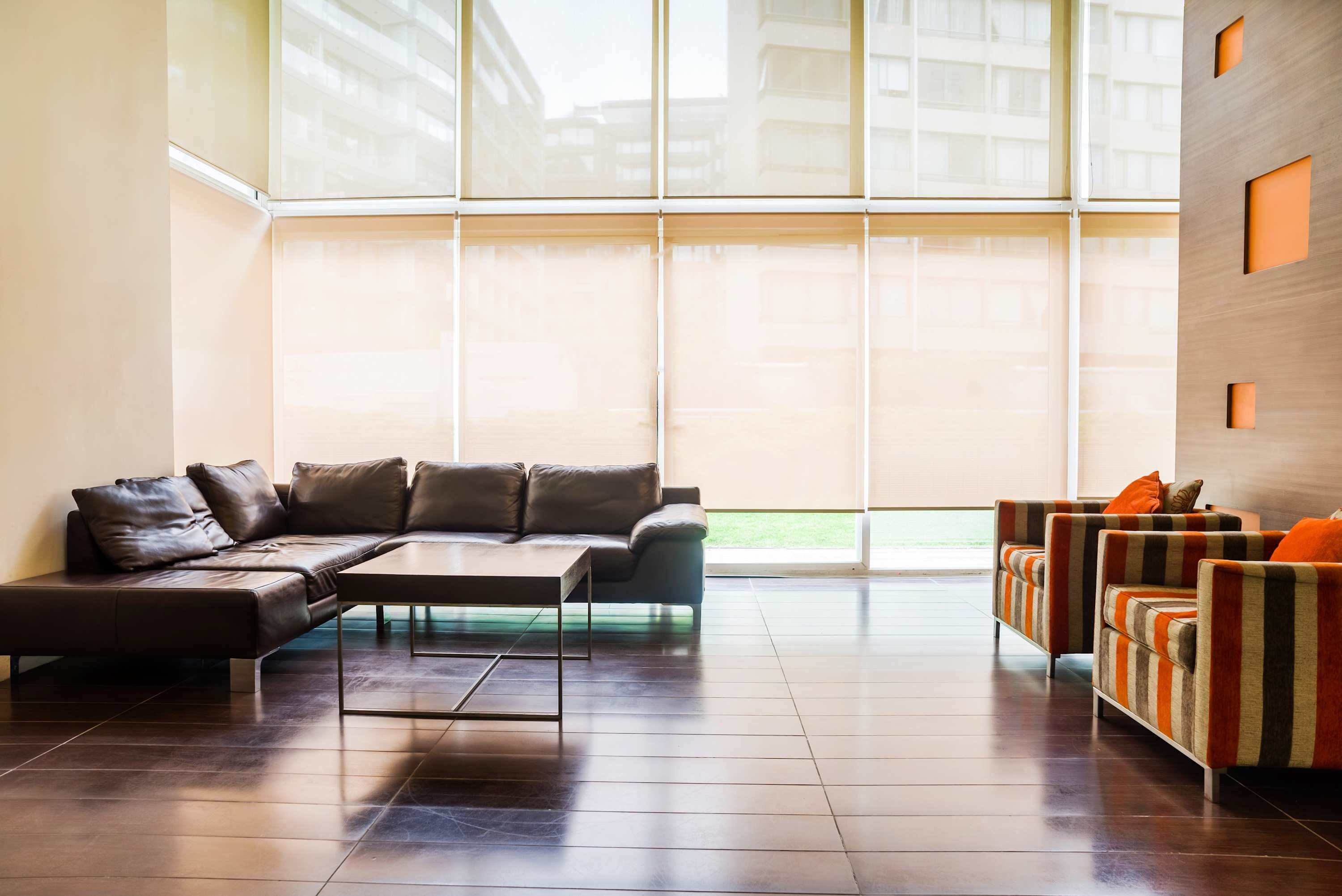 A modern living room with a sectional sofa, a coffee table, and striped armchairs.