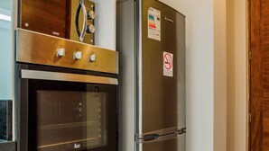 Una cocina con horno empotrado y refrigerador de acero inoxidable.