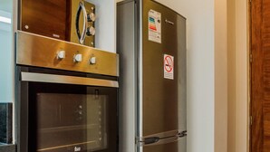 A kitchen with a built-in oven and a stainless steel refrigerator. - Charming Studio in Las Condes with Pool | Ideal 2 (Las Condes)