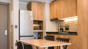 Una cocina moderna con armarios de madera, un microondas integrado y una mesa de comedor con sillas.