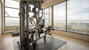 A gym with a large window and a view of the city. - Cozy Apartment Perfect for Families and Long Stays (Las Condes)