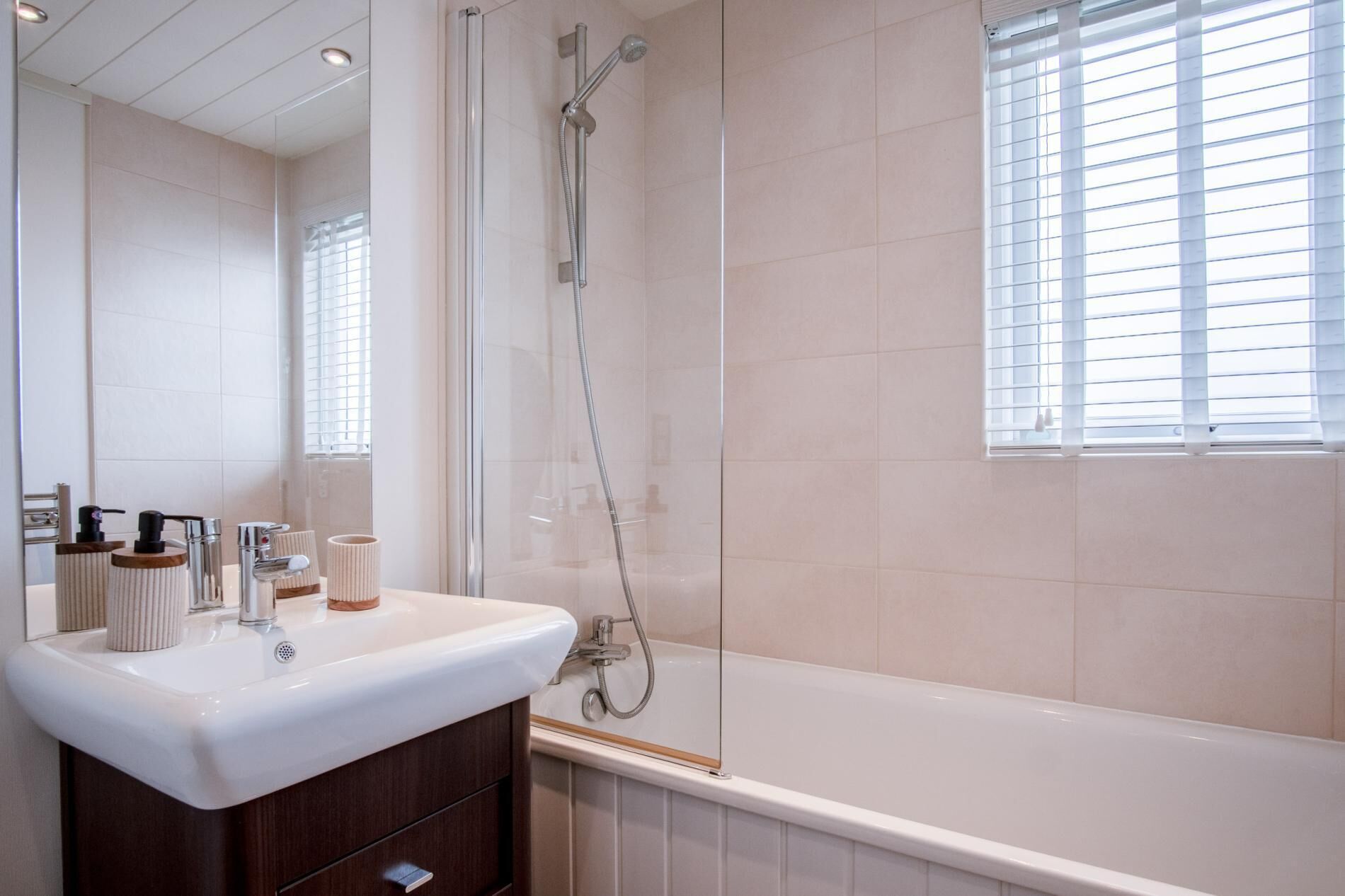 Een moderne badkamer met een wit wastafelmeubel, wastafel en bad.