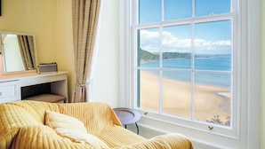 Une chambre avec une grande fenêtre donnant sur une plage.