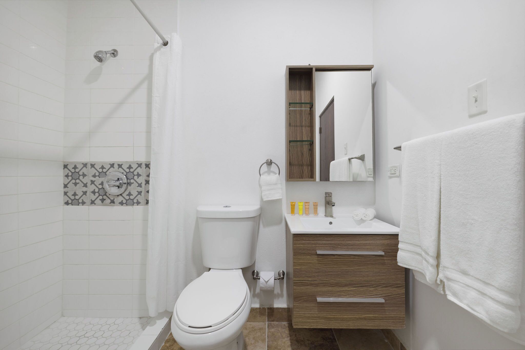 A modern bathroom with a toilet, shower, and vanity.