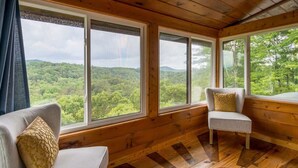 A cabin with large windows offering a view of a forested landscape. - The Stargazers Perch (Blue Ridge)