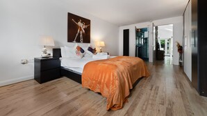 A modern bedroom with a large bed, two bedside tables, a nightstand, and a painting on the wall. - 3 Bedroom Spacious Bungalow Sunningdale Lodge Ascot Racecourse (Sunningdale)