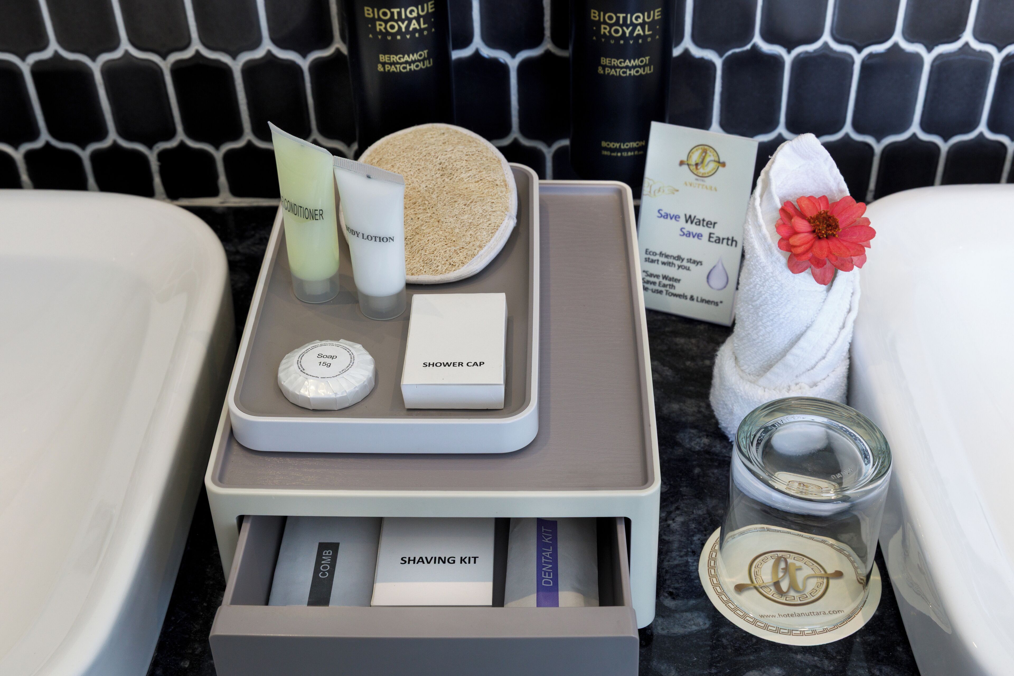 A bathroom vanity with toiletries including a shower cap, soap, conditioner, and a shaving kit.