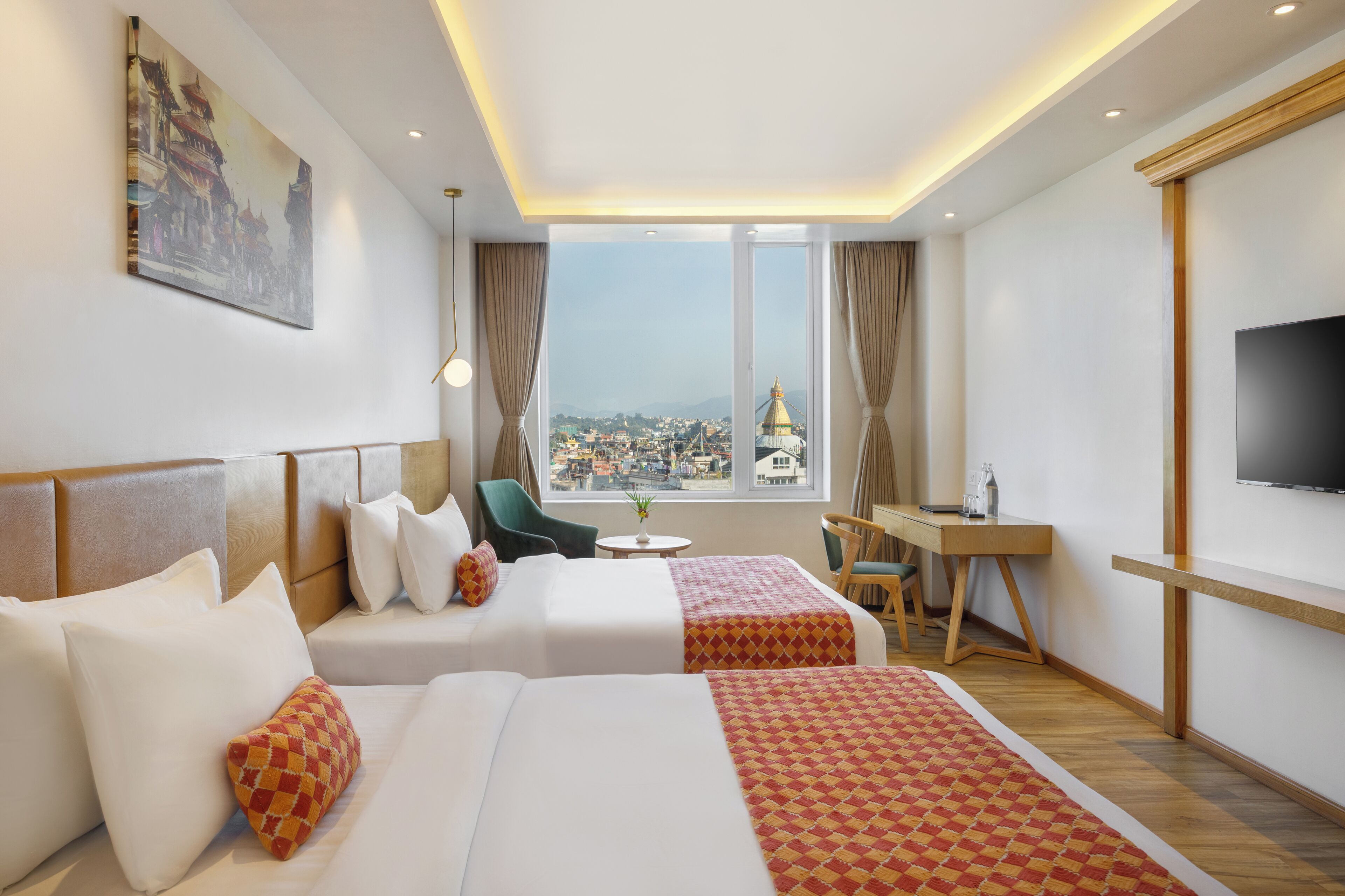 A hotel room with two beds, a desk, a chair, a TV, and a large window with a city view.