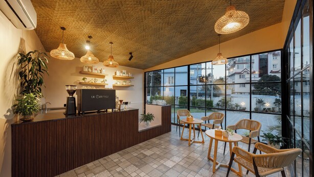A modern reception area with a wooden reception desk, wicker chairs, and pendant lighting. - Hotel Anuttara, Boudha (Kathmandu)
