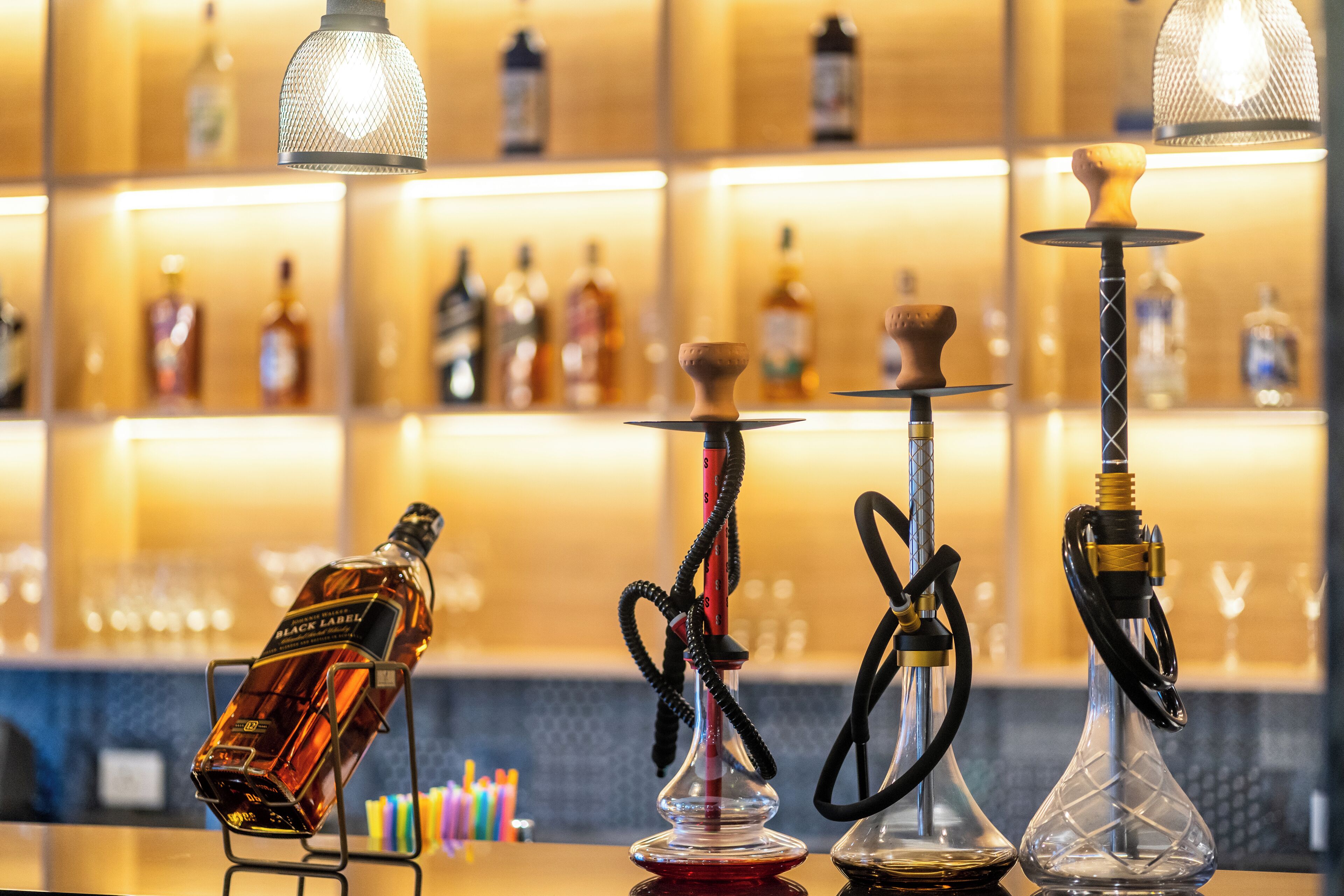 A bar area with various bottles and hookahs.