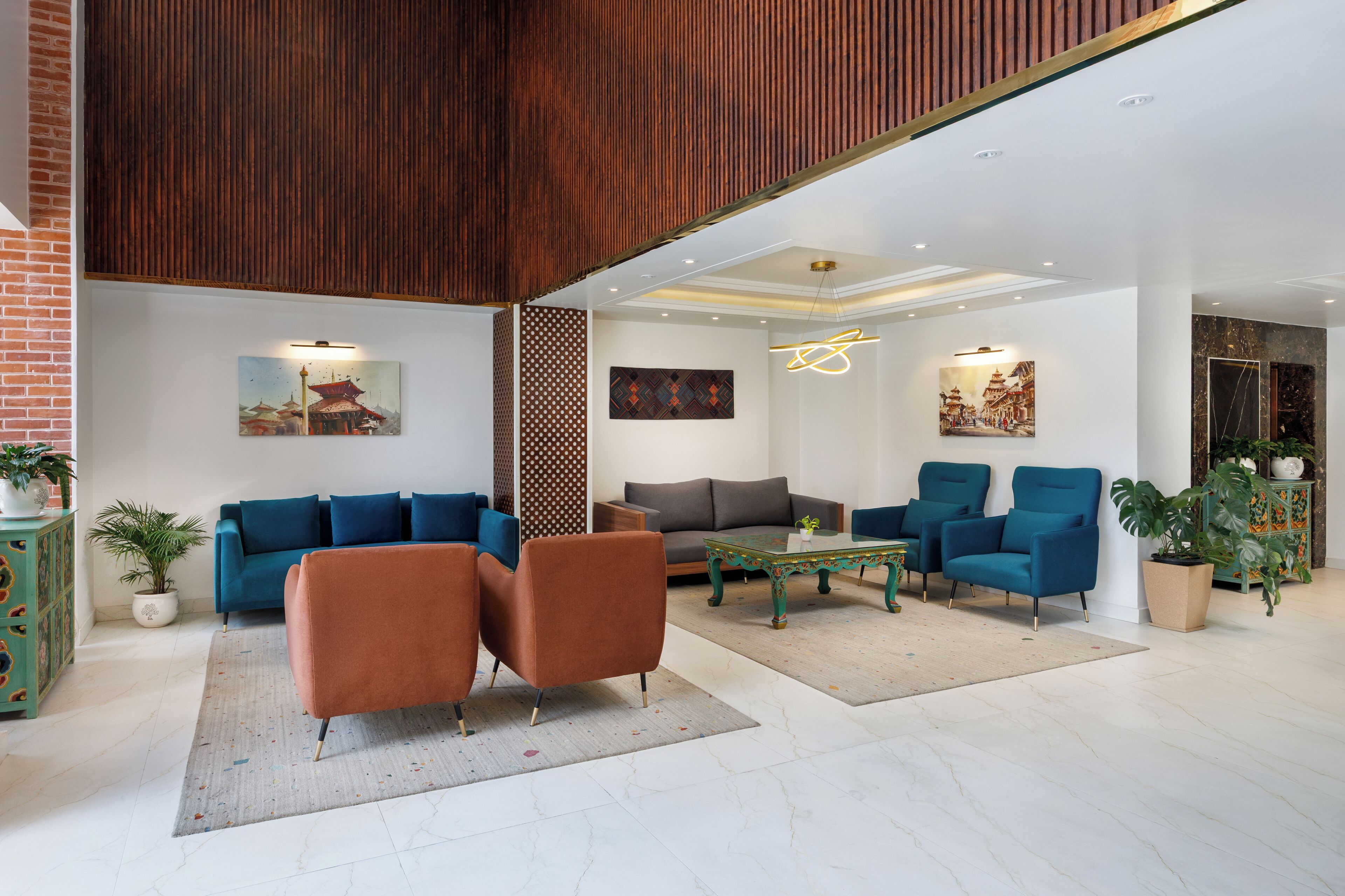 Una sala moderna con sofás azules, un sillón marrón y una mesa de centro verde.