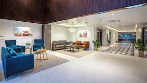 A modern lobby with seating areas, a coffee table, and potted plants. - Hotel Anuttara, Boudha (Kathmandu)