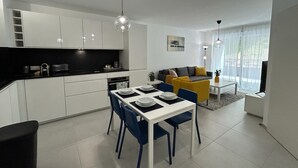 A modern apartment with a kitchen, dining area, and living room.