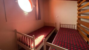 A small room with two single beds, a window, and a wooden slatted wall. - Mezzanine Studio 4P with View, Private Parking - Le Barcarès (Le Barcarès)