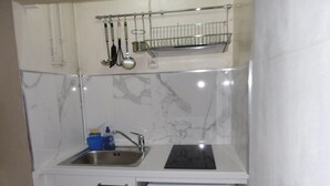A compact kitchen with a sink, a small refrigerator, and a utensil rack above the countertop. - Mezzanine Studio 4P with View, Private Parking - Le Barcarès (Le Barcarès)