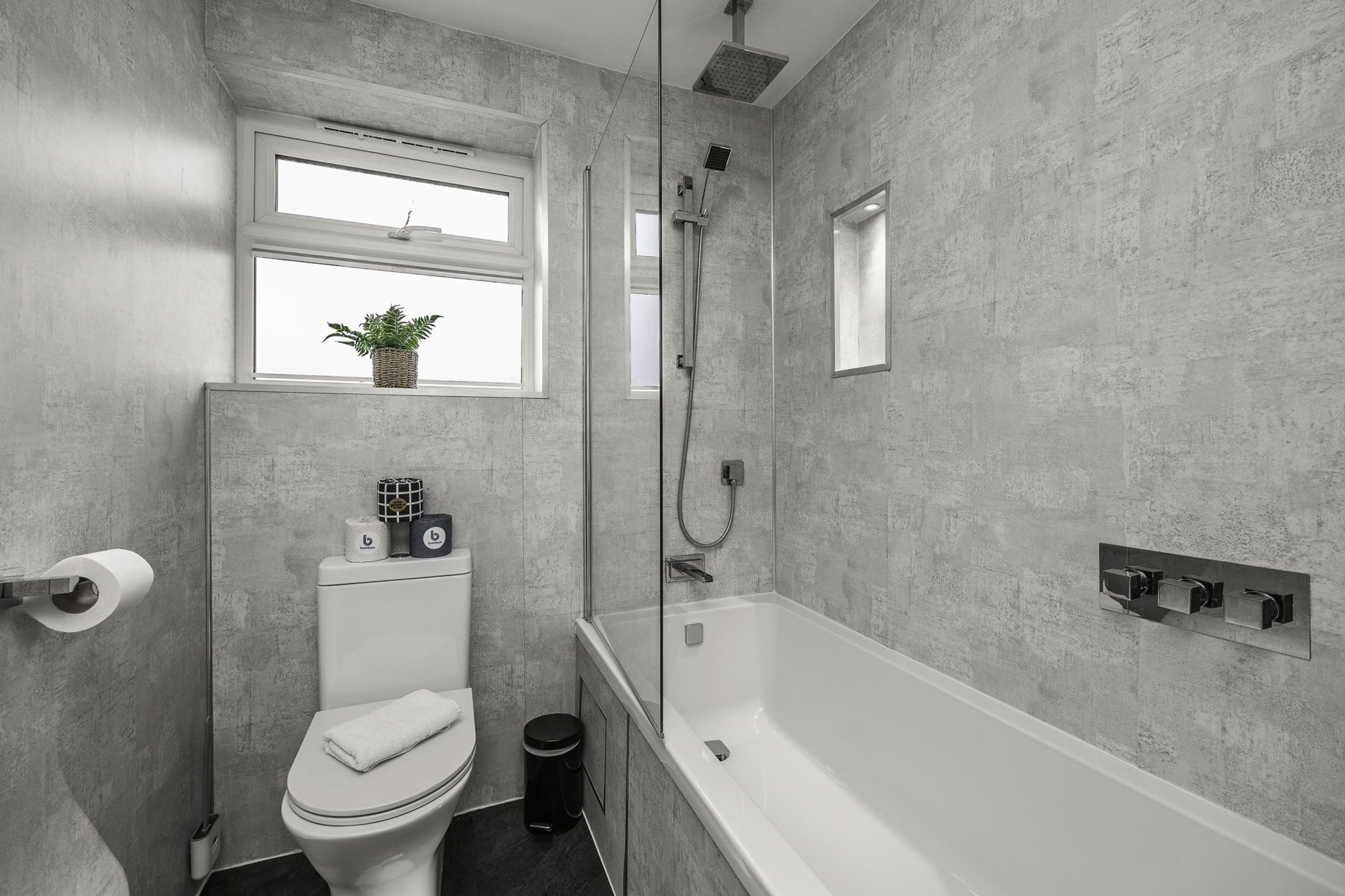A modern bathroom with a toilet, bidet, and bathtub.