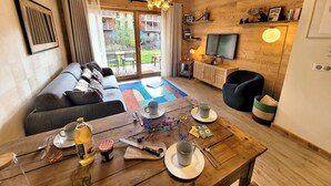 Una sala de estar moderna con un sofá, mesa de comedor y televisor.