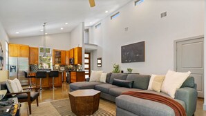 A modern kitchen with wooden cabinets, a bar area, and a dining table. - 2915 E 14th xxxxxxxx (Austin)
