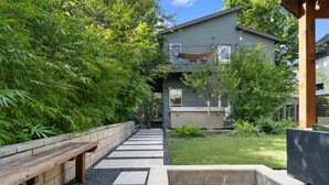 A pathway leading to a house with a covered porch and a garden area. - 2915 E 14th xxxxxxxx (Austin)