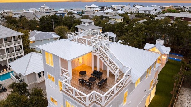 Un edifici de diversos pisos amb una zona de terrat que disposa de mobiliari exterior.