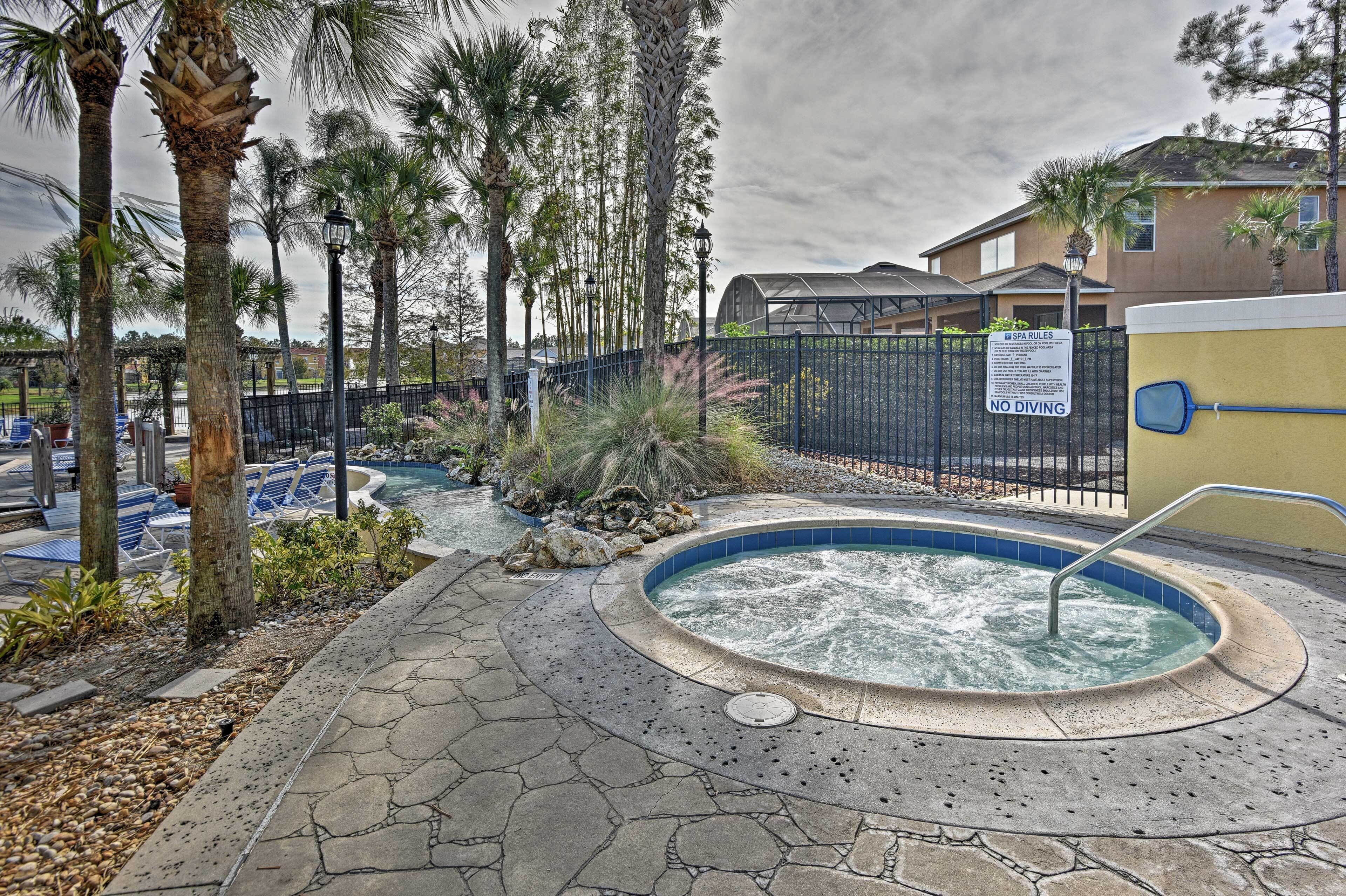 A pool area with a hot tub, palm trees, and a fence with a 'No Diving' sign.