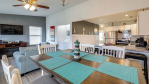 A modern kitchen with a dining area, a ceiling fan, and a lighthouse decoration. - North Topsail Beach Townhome: Walk to the Beach! (Sneads Ferry)