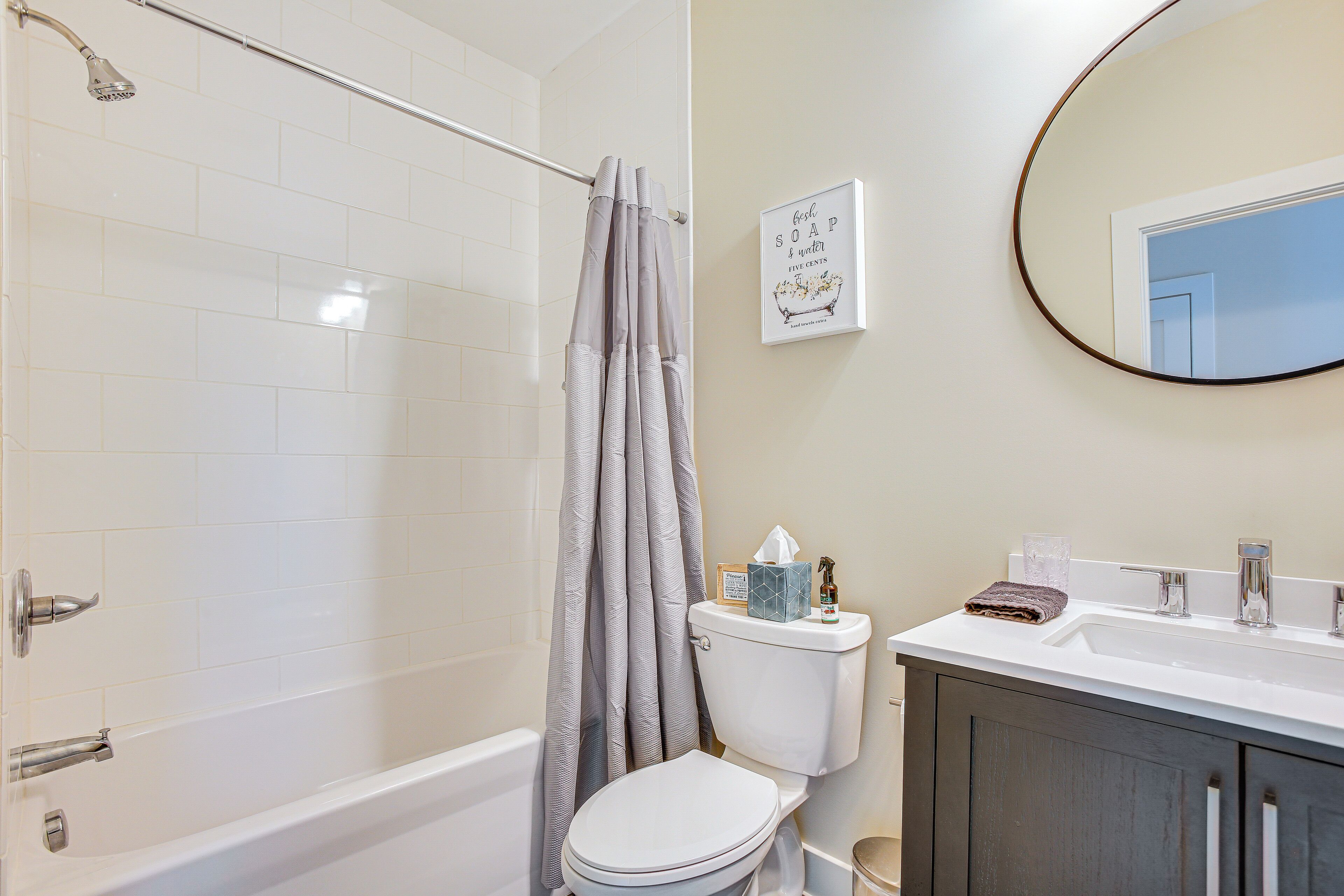 Une salle de bain équipée d’une douche, de toilettes, d’un lavabo et d’un miroir.