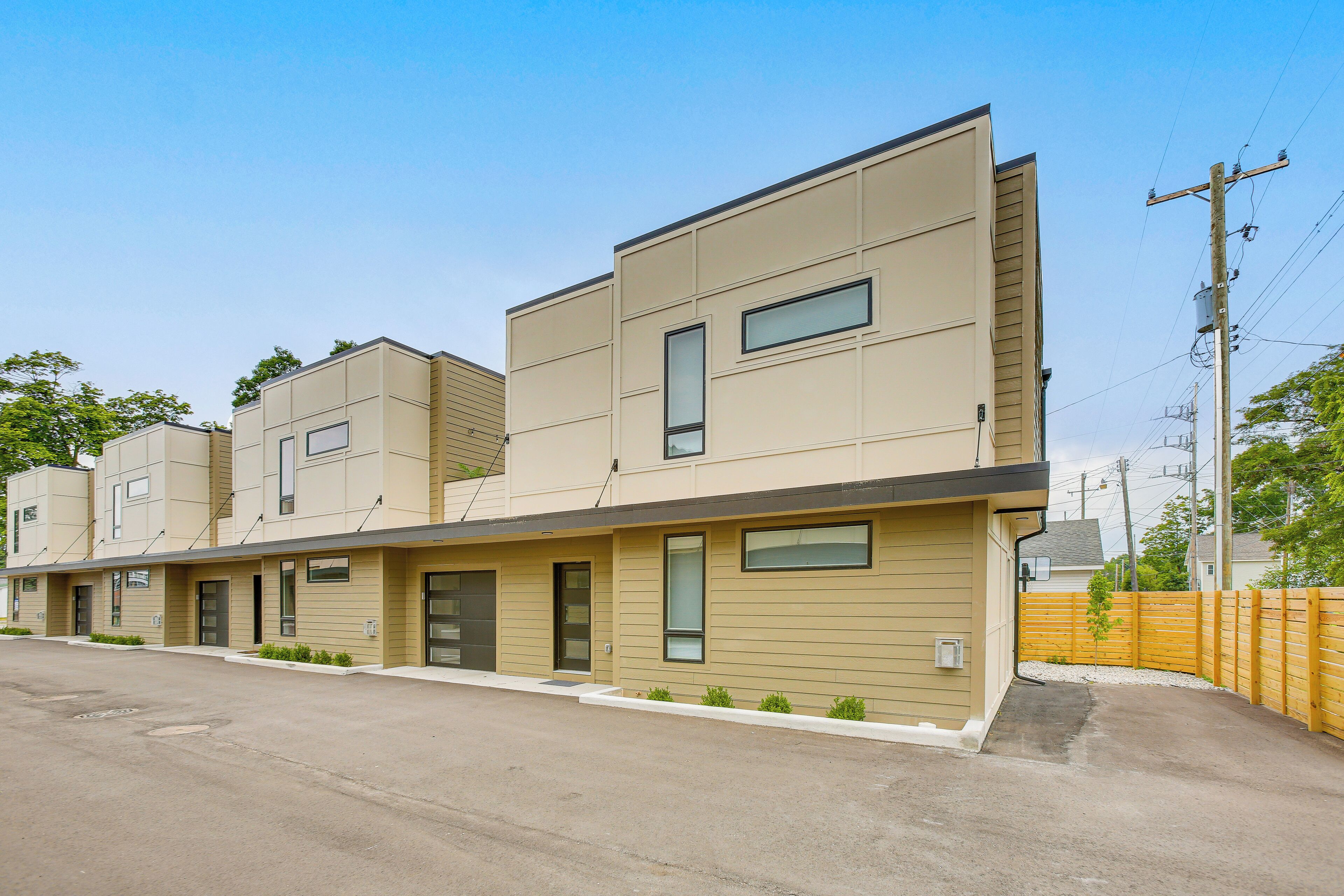 Un moderno edificio residencial de varios pisos con techo plano, amplias ventanas y un diseño limpio y minimalista.