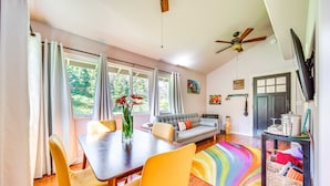 Un coin repas avec une table en bois, des chaises jaunes et un tapis coloré.
