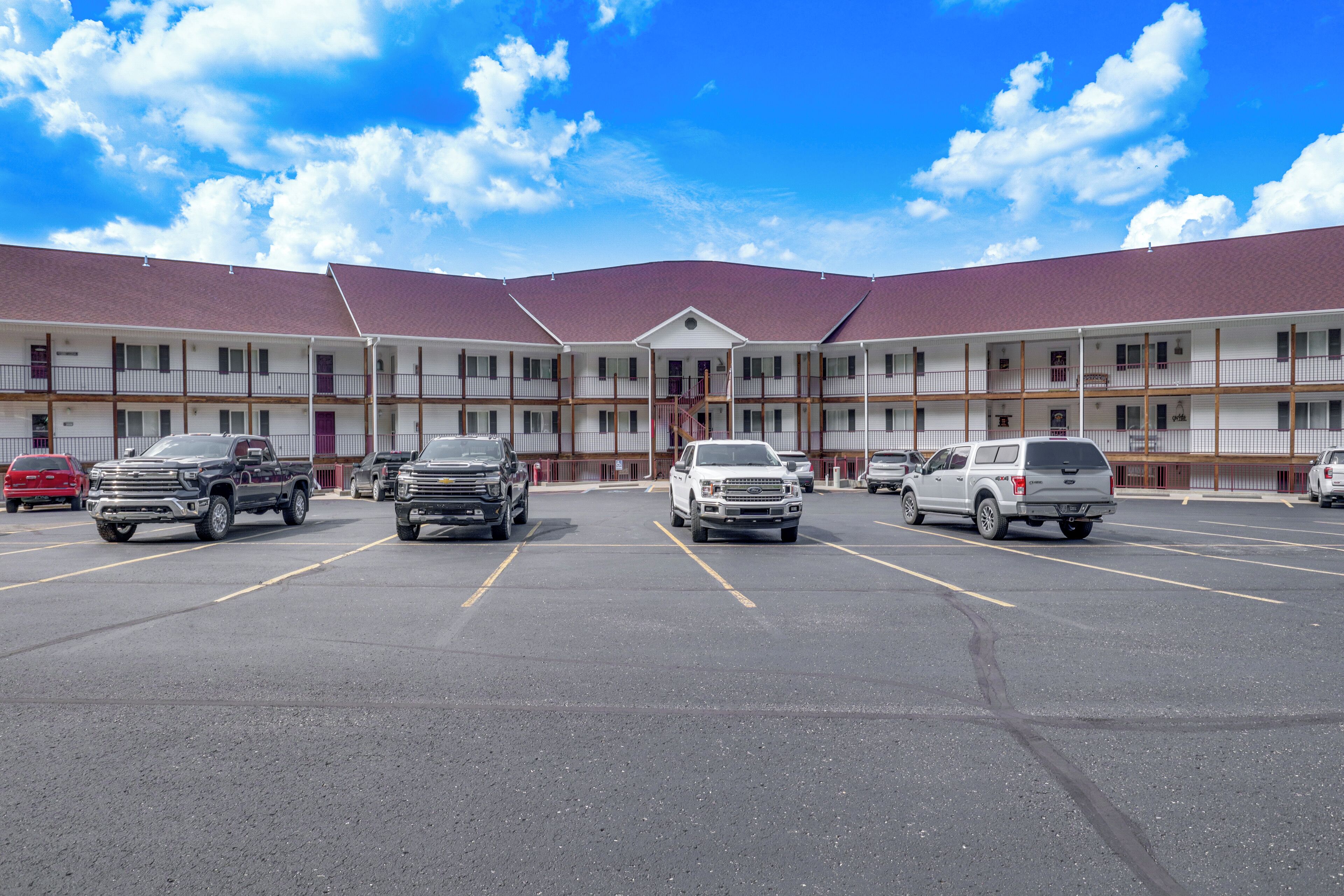 Un motel à plusieurs étages avec un parking.