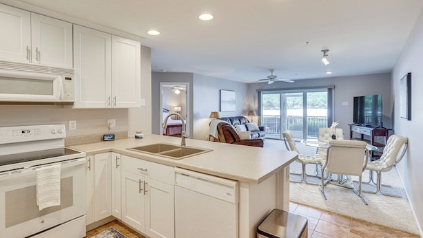 A modern kitchen with white cabinetry, a built-in microwave, and a dishwasher.