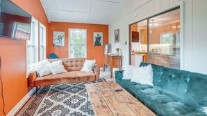 Un salon avec un canapé, une table basse et un téléviseur.