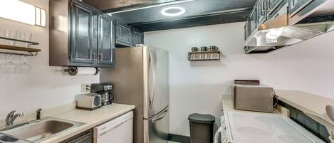 A compact kitchen with a stainless steel refrigerator, a toaster, and a sink.