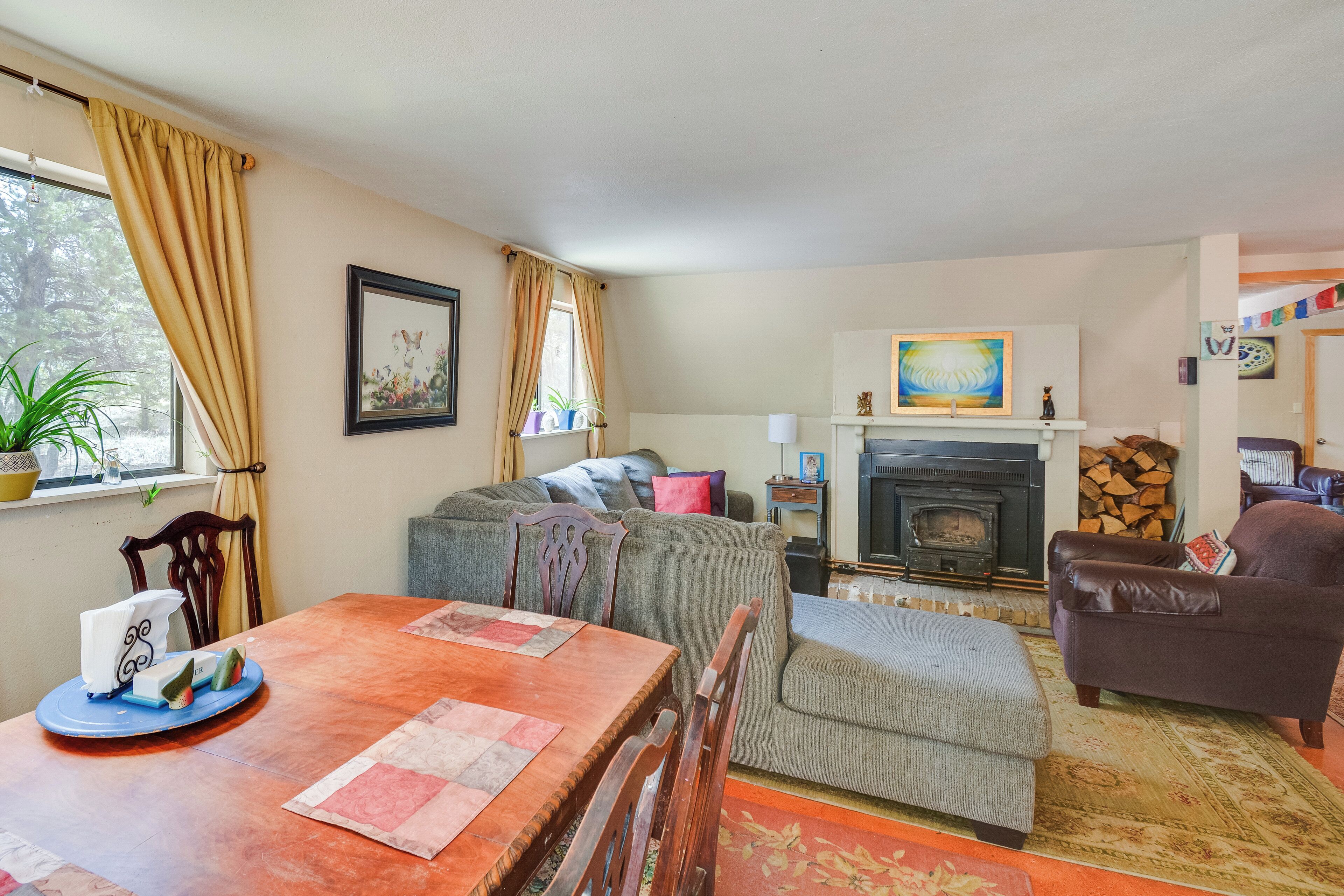 A living room with a fireplace, a dining table, and a sofa.