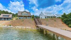 A wooden dock leading to a house with a staircase. - Waterfront Alexander City Home w/ Private Dock! (Alexander City)