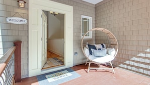 A porch with a wicker chair, a welcome sign, and a doormat. - Black Mountain Hideaway w/ Hot Tub & Pool Table! (Black Mountain)