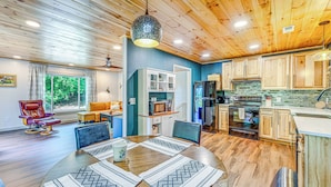 A modern kitchen with wooden cabinets, a built-in oven, and a large window. - Renovated Franklin Home w/ Mountain-view Deck! (Franklin)