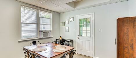 A dining area with a wooden table, black chairs, and a white door.