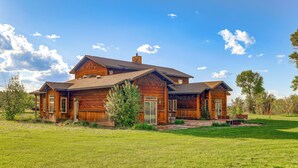 A large wooden house with a spacious front yard and a clear blue sky. - Spacious Afton Home: Patio, Grill & Mountain Views (Afton)