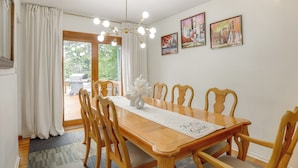 A dining area with a wooden table, chairs, a chandelier, and artwork on the walls. - Somerset Home w/ Large Yard Near Parks & Trails (Somerset)