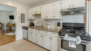 A kitchen with white cabinets, a stainless steel stove, and a tiled backsplash. - Somerset Home w/ Large Yard Near Parks & Trails (Somerset)