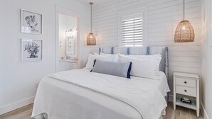 A bedroom with a bed, bedside tables, and wall-mounted artwork. - Bird Feather 160tai - C (Port Aransas)