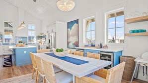 A spacious kitchen with a large island, white cabinetry, and a view of the outdoors. - The Seaward 217 STA (Port Aransas)