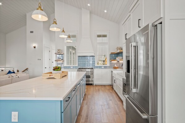 A modern kitchen with white cabinetry, stainless steel appliances, and a large island. - The Seaward 217 STA (Port Aransas)